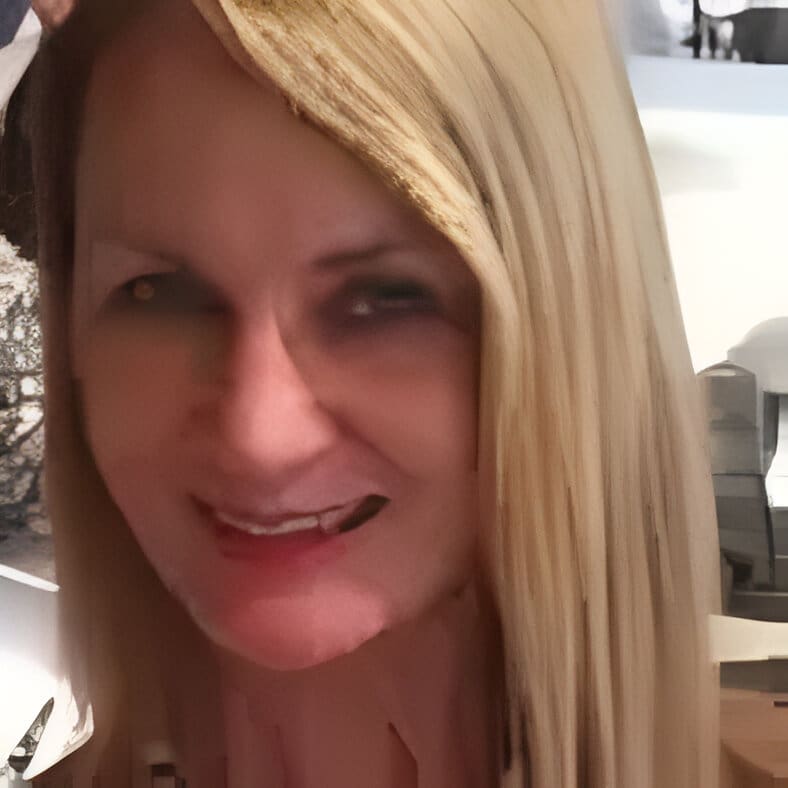 pixelcut-export A woman with long blonde hair smiles for the camera.